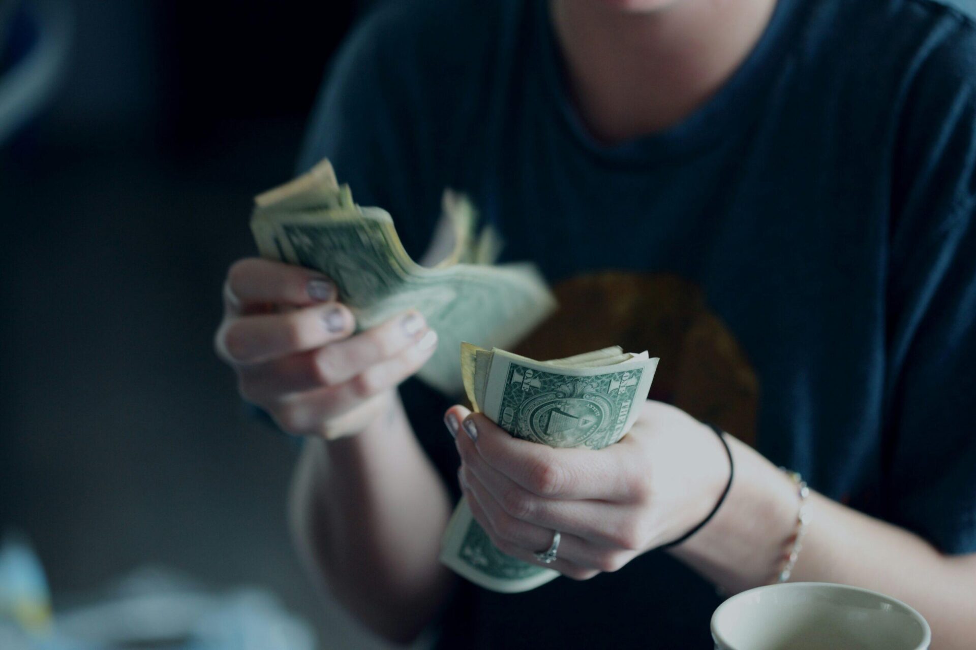 focus-photography-of-person-counting-dollar-banknotes